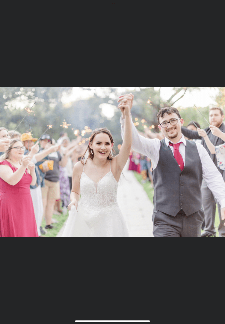 Newlywed couple joyfully celebrates their marriage surrounded by cheering guests.