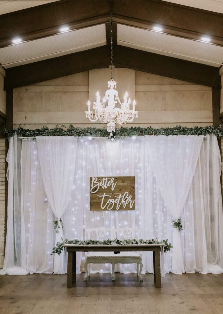 Elegant wedding altar with chandelier and floral decorations.