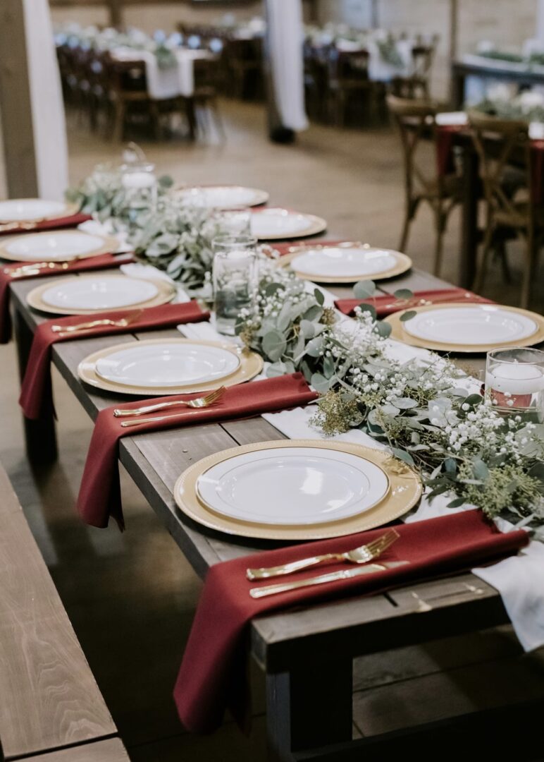 Elegant table setting with white plates, gold cutlery, and floral centerpiece.