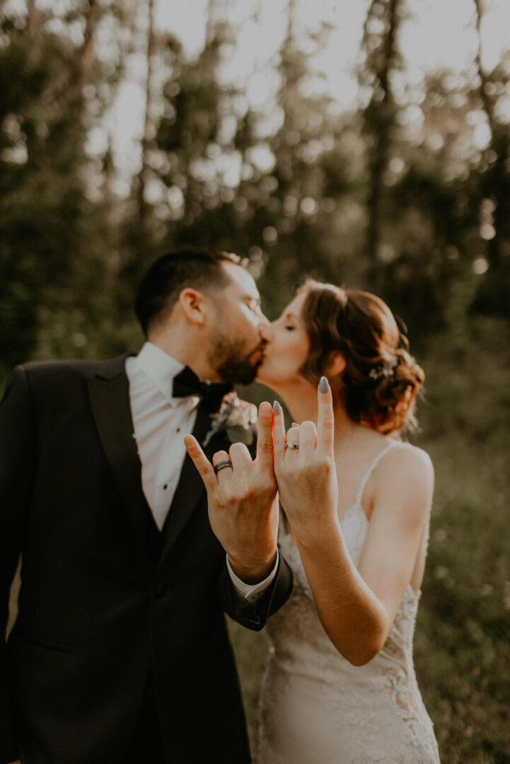 Couple kissing with rock hand gesture.